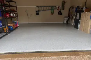 This is a wide photo of epoxy garage floor makeover with a light grey, white and soft blue  polymer flake